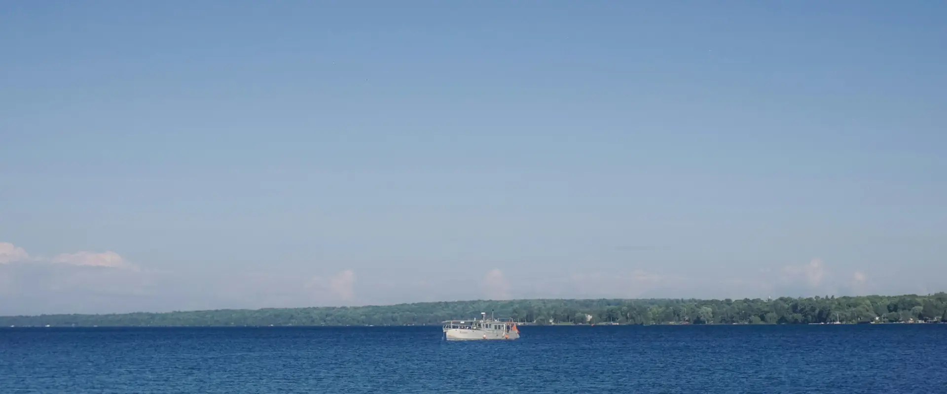 A boat crossing Kempenfelt Bay on a clear summer day